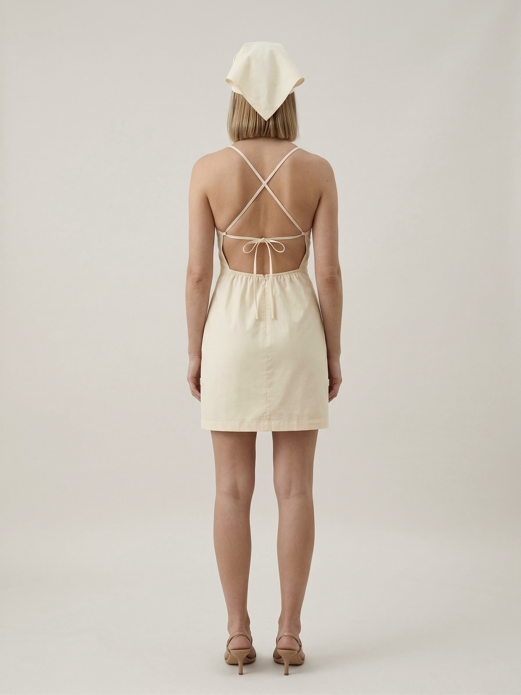 Butter yellow mini dress with open back and cross straps back view
